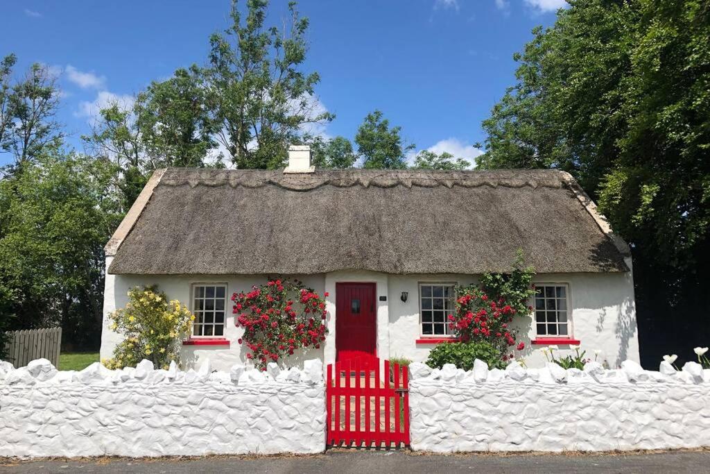 ArboeClannad Cottage的白色的小房子,带有茅草屋顶