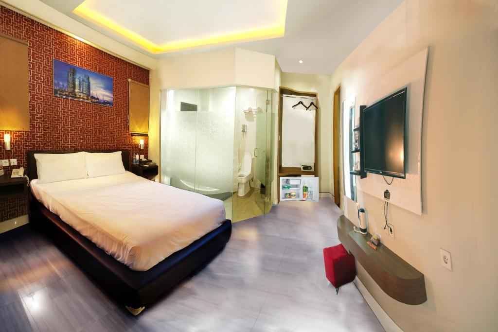 雅加达安东尼酒店的一间卧室配有一张床和一台平面电视