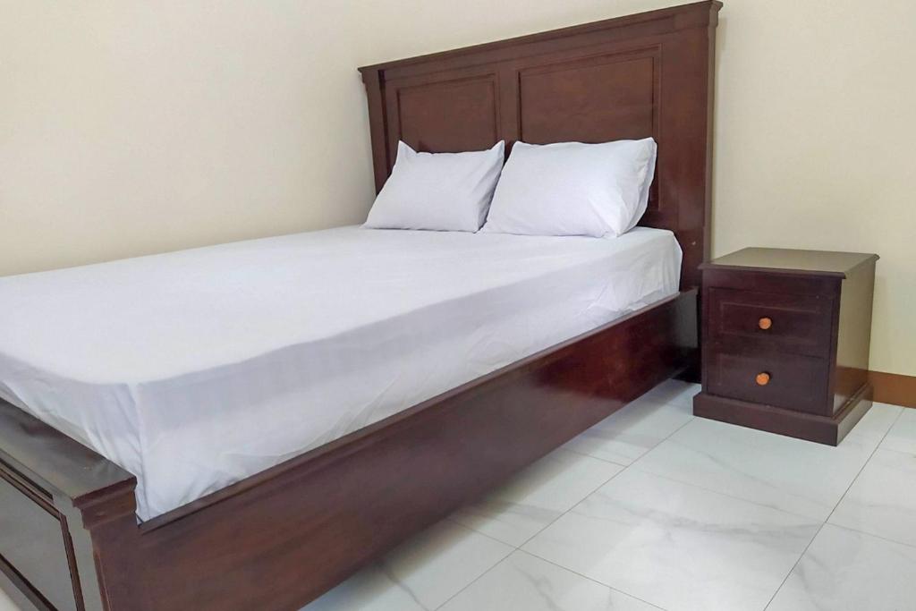 ComalRedDoorz Syariah near Exit Tol Pemalang的一张带木制床架和床头柜的床
