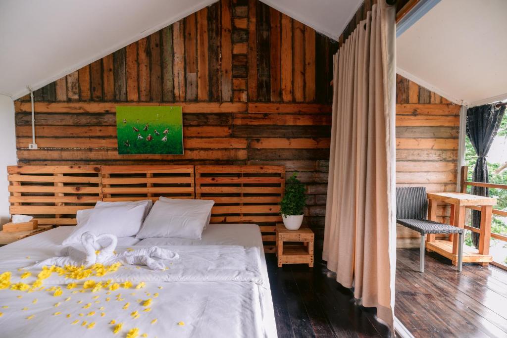 沙璜Beu Ceubeh Cottage Sabang的一间卧室设有一张床和木墙