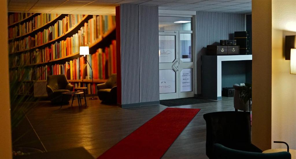 开姆尼茨Rothenberger的图书馆配有书架和椅子,红色地毯