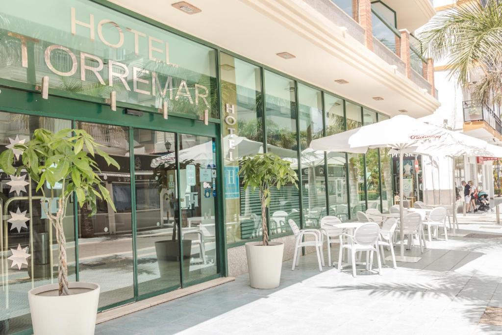 托雷德尔马尔Hotel Torremar - Mares的大楼外带桌椅的餐厅