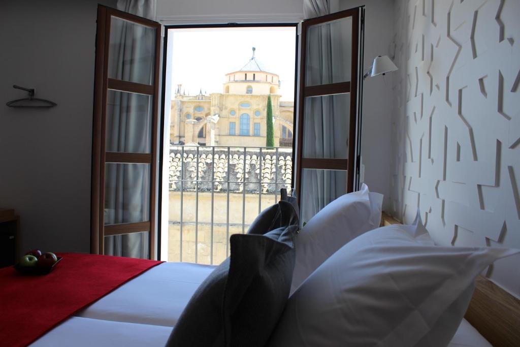 科尔多瓦流苏精品酒店的卧室设有窗户,享有教堂景致