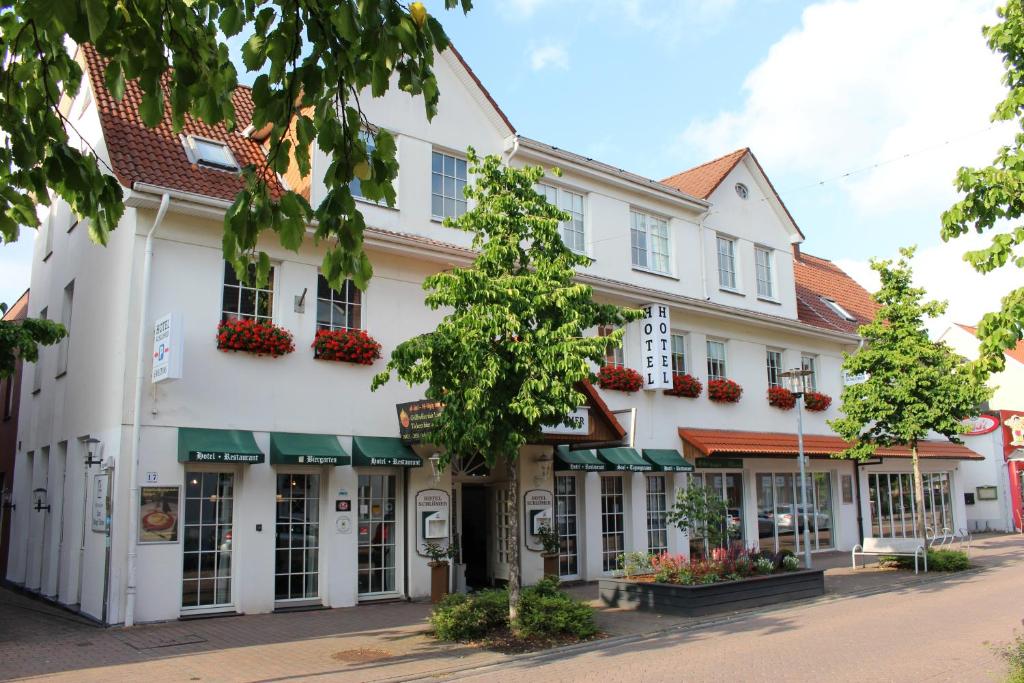 克洛彭堡Hotel Schlömer的白色的建筑,窗户上摆放着鲜花