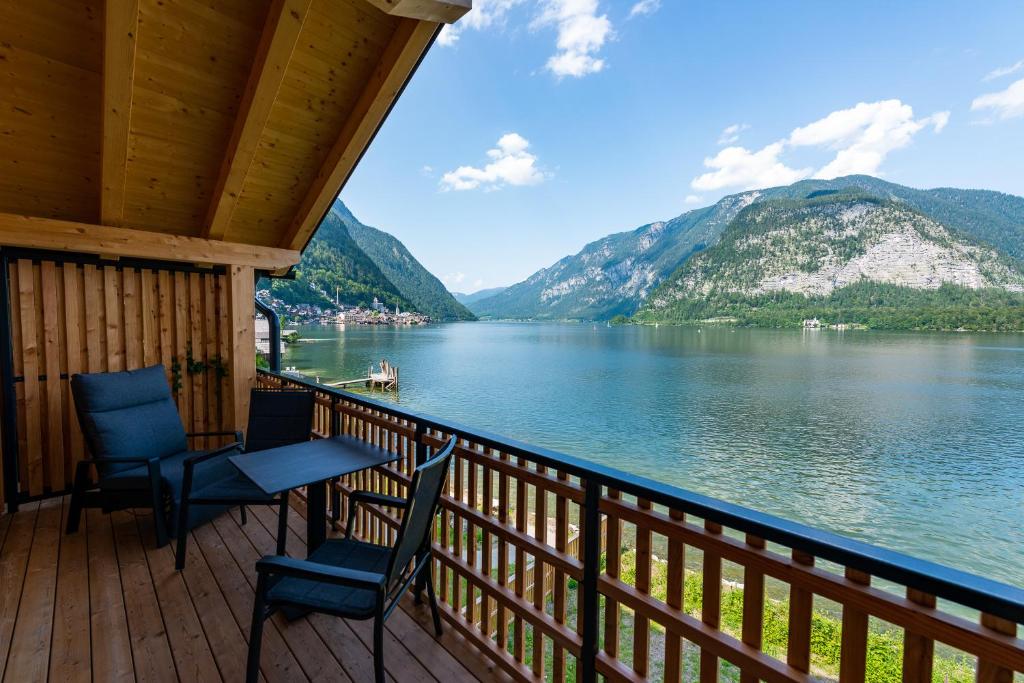 哈尔施塔特Boutiquehotel Strand Hallstatt - Adults only的湖景门廊配有2把椅子和1张桌子