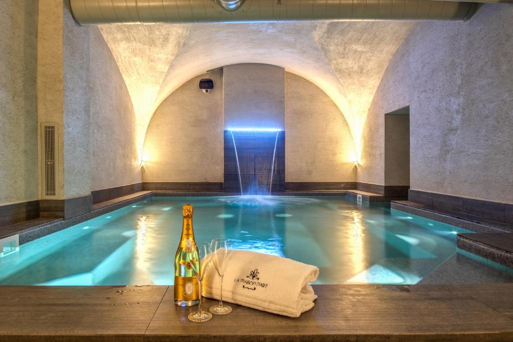 罗马Hotel 77 Seventy-Seven - Maison D'Art Collection的游泳池旁的一瓶葡萄酒