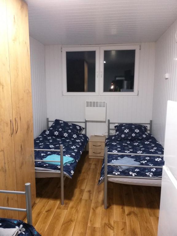 马佐夫舍地区格罗济斯克Domek N5 - 2 Pokoje , Kuchnia , Łazienka 5 osobowy - FreezerHause Izdebno- NoclegiGrodziskPL的一间卧室设有两张床和两个窗户。