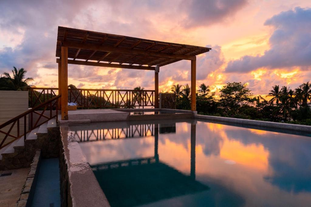 圣法兰西斯克Ciyé Hotel的一座享有日落美景的游泳池