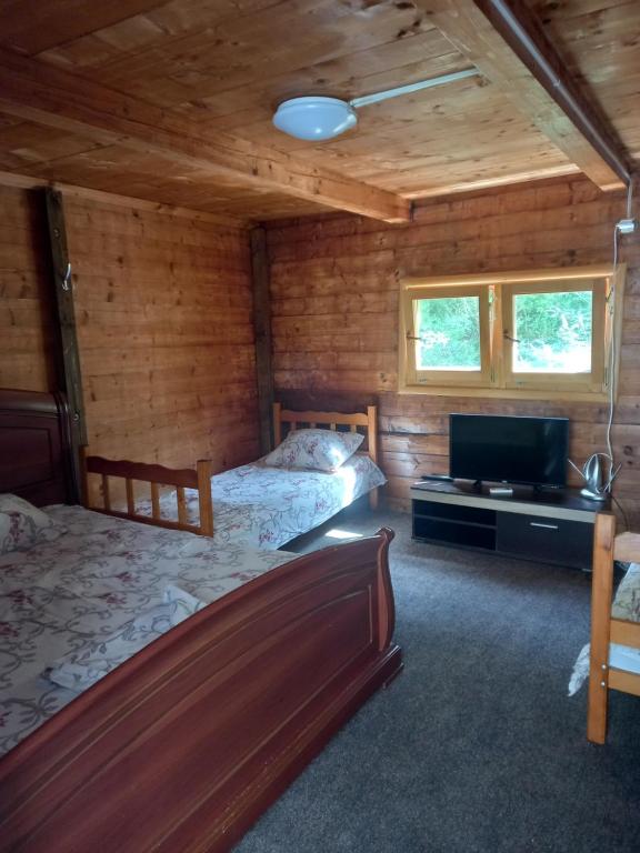 安吉Vikendica的一间卧室配有两张床和一台平面电视
