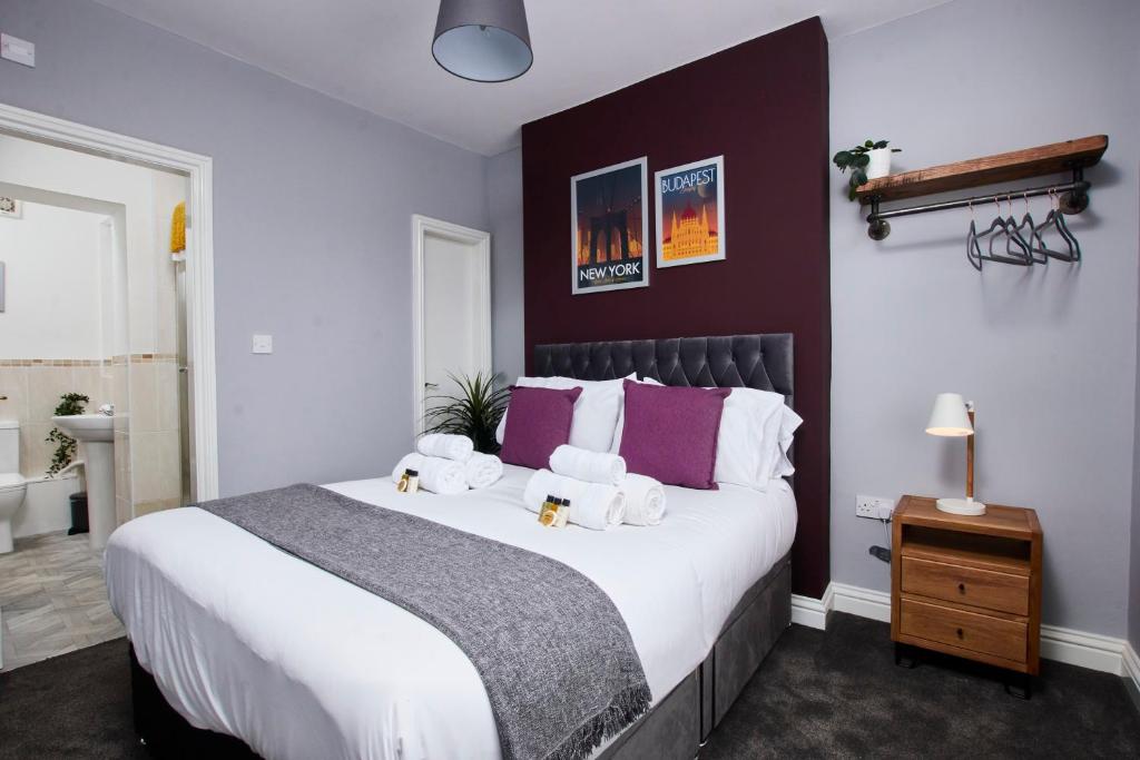 达宁顿堡Delven House, Apartment 4的卧室配有一张白色大床和紫色墙壁