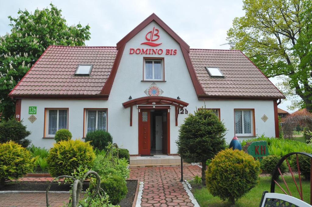 德兹维济诺Ośrodek Wczasowy Domino Bis的上面有多米诺斯标志的房子
