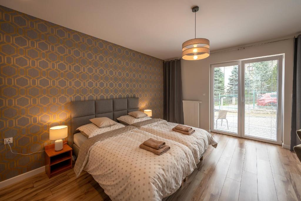 隆代克-兹德鲁伊Apartamenty Mozaika - centrum Zdroju的一间卧室配有一张大床和两个枕头
