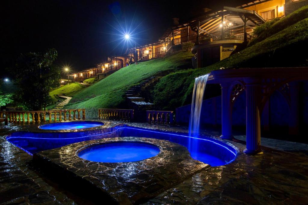 萨兰托Rancho San Antonio的夜间在院子中间带瀑布的游泳池