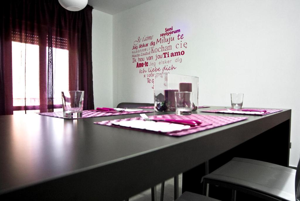 阿谢亚inStile aparthotel的一张桌子,上面有粉红色的桌布和眼镜