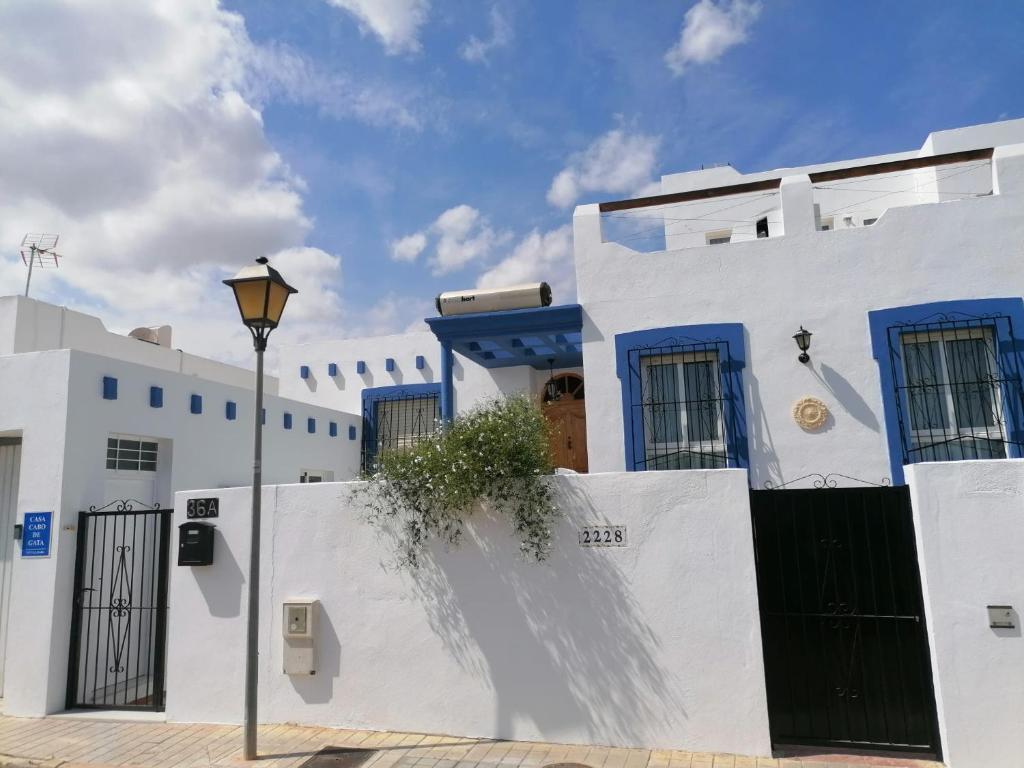 雷塔马尔Casa Cabo de Gata的白色的建筑,有蓝色的门和街灯