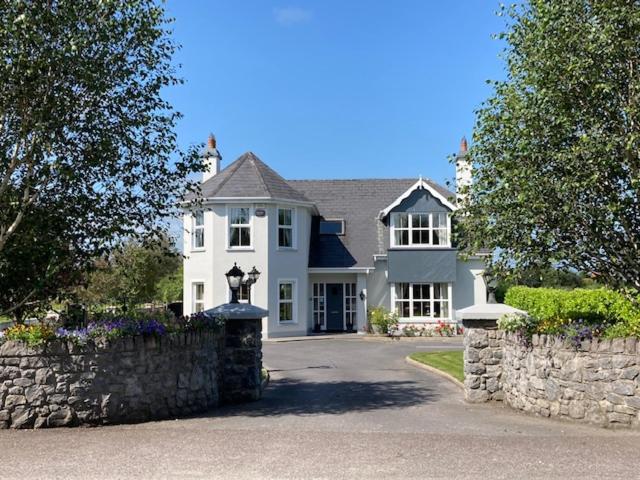 卡斯莱兰Tailors Lodge, Luxurious peaceful Apartment- Castleisland, Kerry的一座白色的大房子,设有石墙