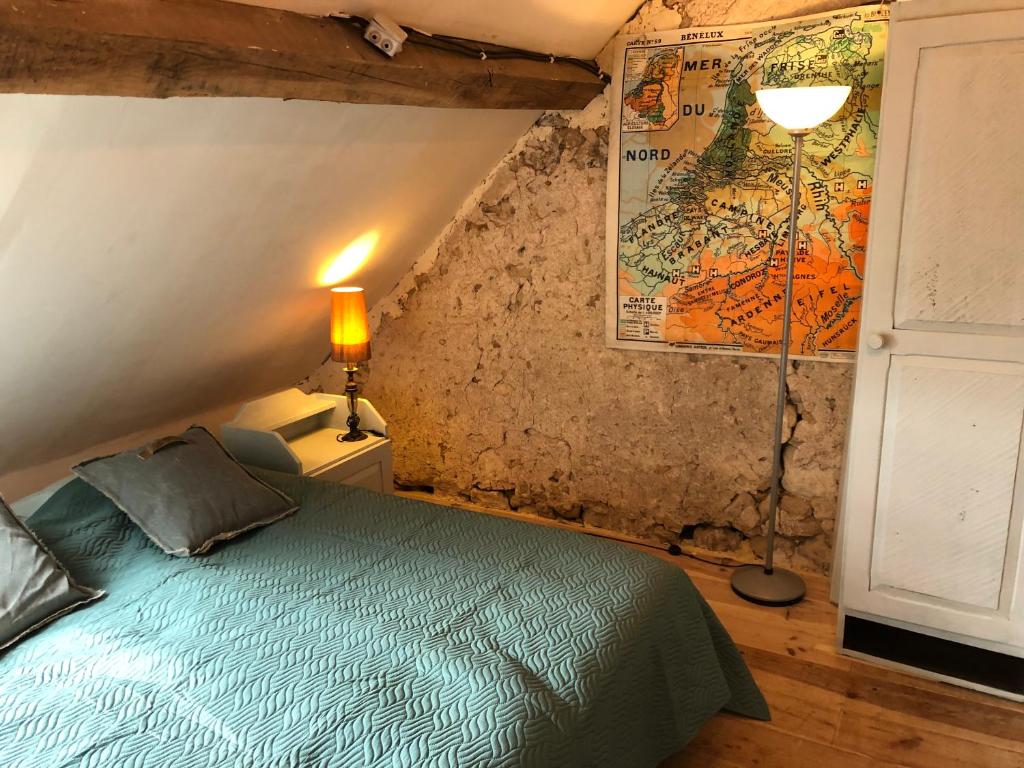 PouilléCôte du Jardin的卧室配有一张床,墙上有地图