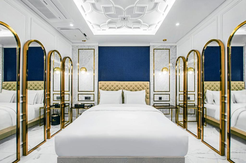 首尔Hotel the Castle bangi 2nd的一间卧室配有一张金色床架的大床