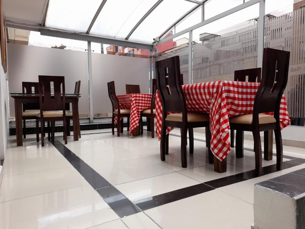 波哥大Embassy On Holidays的用餐室配有红色和白色的桌椅