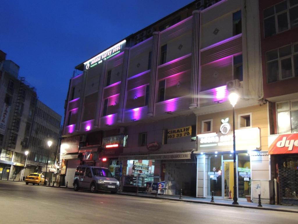 阿达纳阿达纳萨拉伊酒店的街道边有紫色灯的建筑