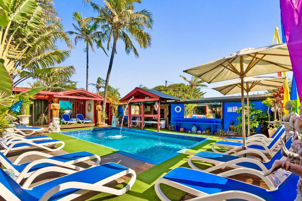 佩里吉安比奇亥努沙男性专用海滩度假酒店的一个带躺椅和遮阳伞的游泳池