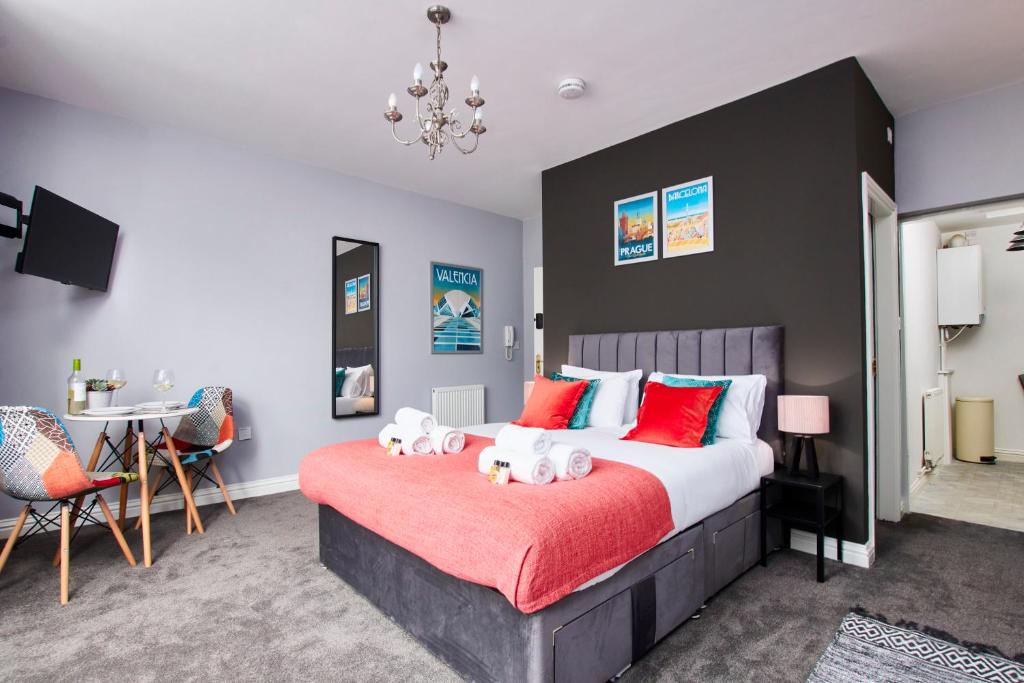 达宁顿堡Delven House, Apartment 2 - Self Check-in, Self-Catering Serviced Apartment for East Midlands Airport的一间卧室配有一张带红色枕头的大床