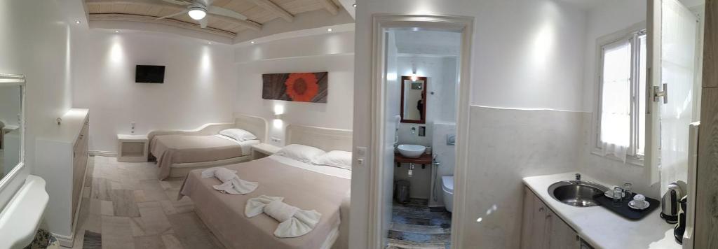 阿吉奥斯普罗科皮奥斯Ostria Hotel的白色的浴室设有浴缸和水槽。