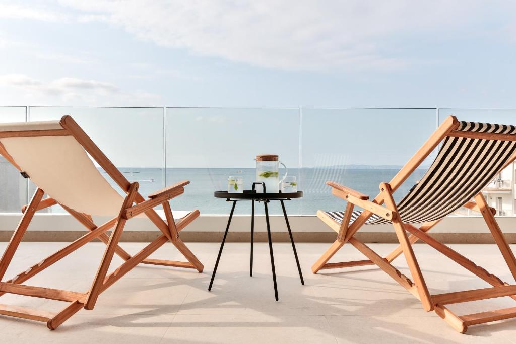 罗萨斯ECO-APARTMENTS LA MARINEDA的两把木椅和一张桌子,位于窗户前