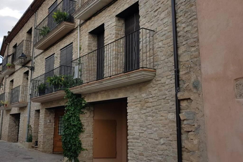 MontsonisCASA GRAN MONSONIS的一面是一栋砖砌建筑,旁边设有阳台