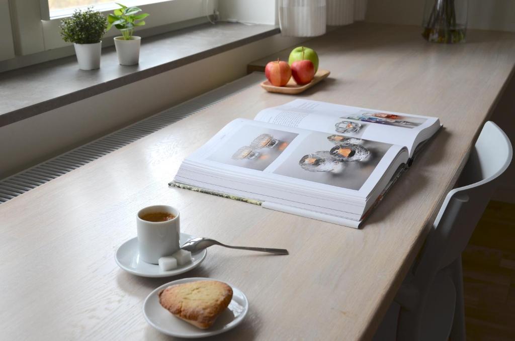 隆德Forskarhotellet的一本书,一杯咖啡和一盘面包
