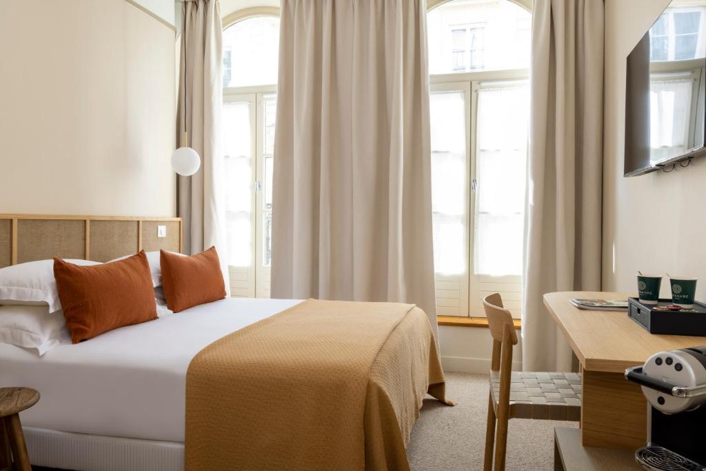 巴黎Hôtel Joe M的卧室配有一张床、一张书桌和窗户。