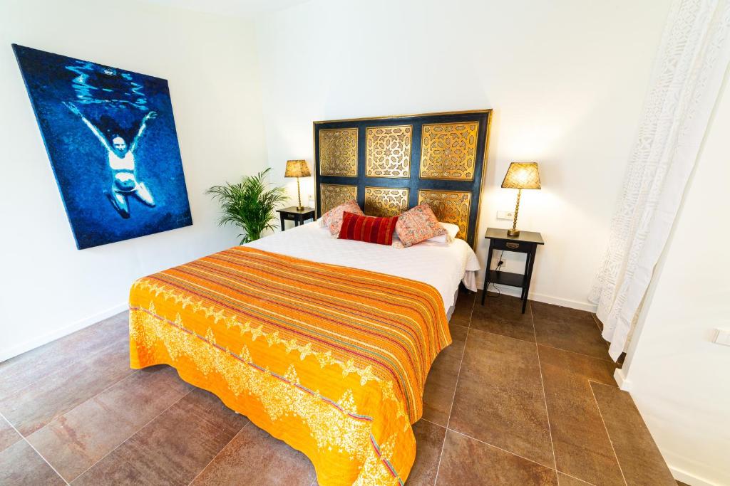 萨波夫拉Flor de Mandarina的卧室配有一张床,墙上挂有绘画作品