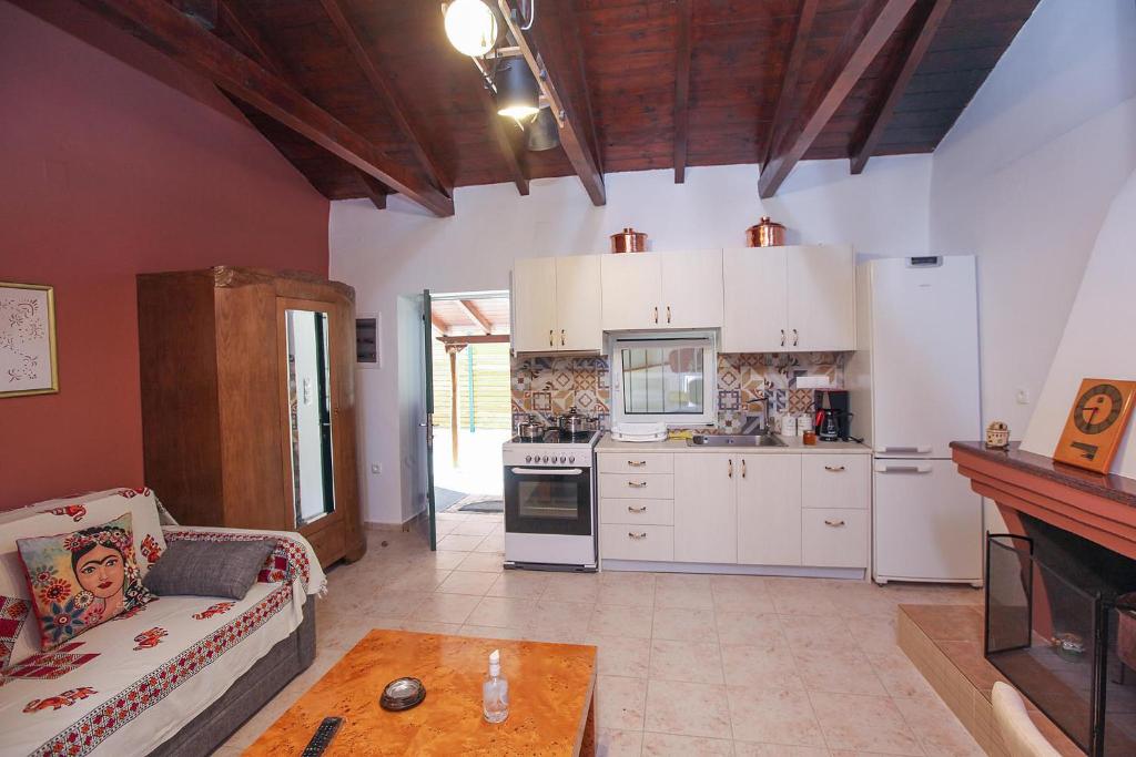AnífionTraditional Guesthouse Asimakis Anifion的厨房配有白色橱柜、沙发和桌子