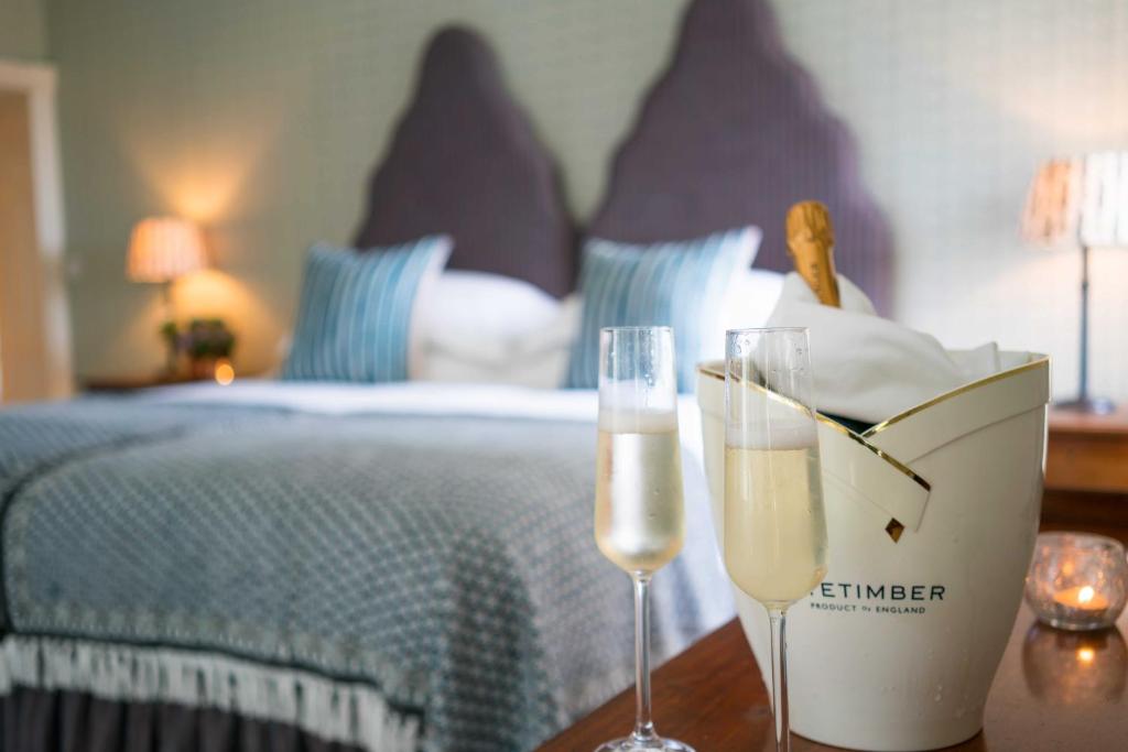 Newbiggin高力酒店的睡床旁桌子上放两杯香槟