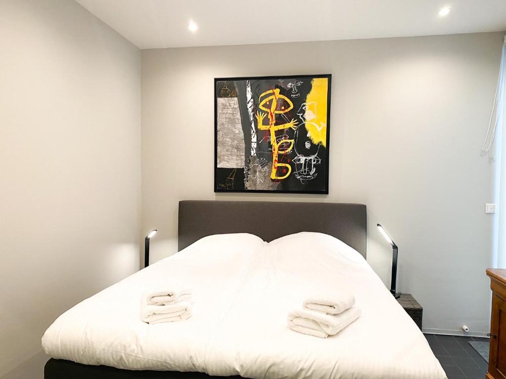 弗利辛恩Studio KA06 Het Strandhuis的卧室配有白色床和2条毛巾