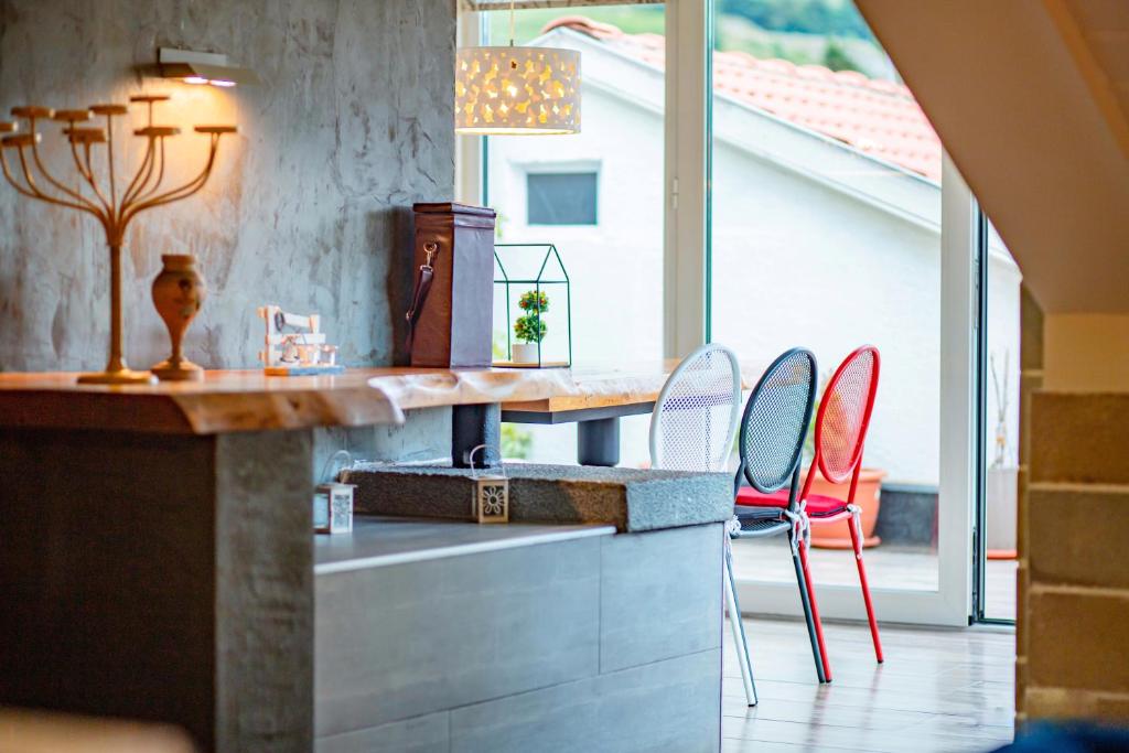 戈里察Meri Boutique Hotel的厨房配有红色的椅子和带桌子的柜台。