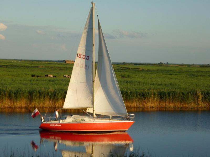 斯维诺乌伊希切Siedlisko Nad Rozlewiskiem的水面上的红白帆船