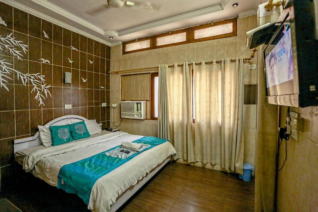 德拉敦The Trekkers Hostel - Dehradun的一间卧室配有一张床和一台电视