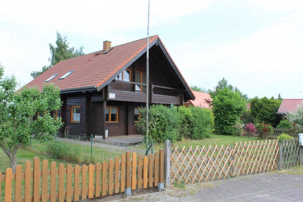 LoissinHolzblockhaus mit Kamin am Kite , Surf und Badestrand的前面有围栏的木屋
