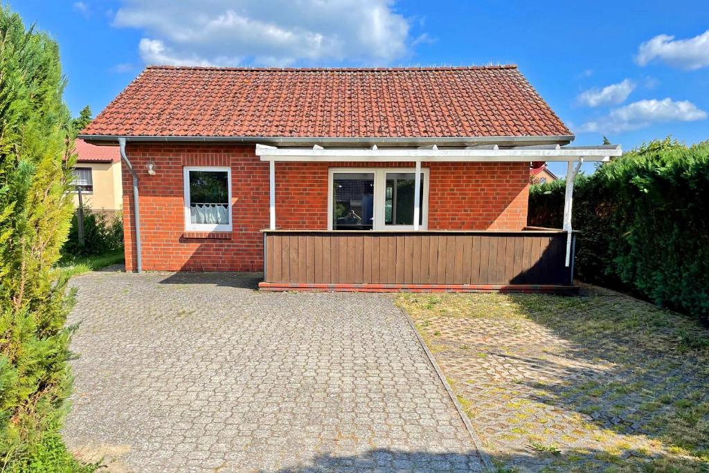 克林克Ferienhaus Klink SEE 6001的一座红砖小房子,设有木制车库