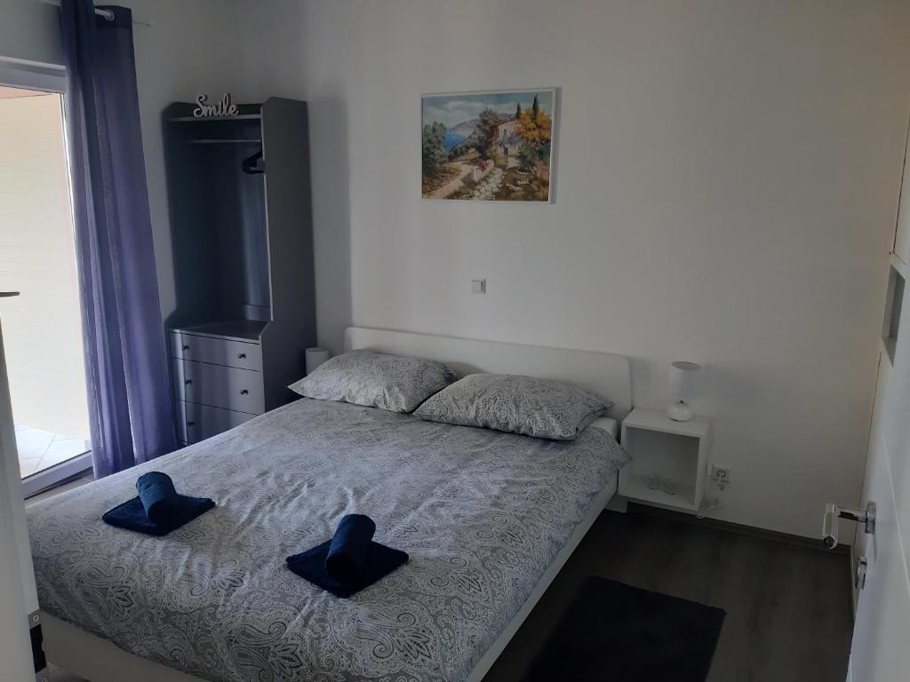 弗尔Natasa apartments Krk的一间卧室配有一张带蓝色拖鞋的床。