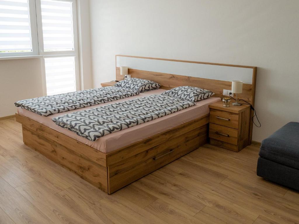 卡鲁扎Apartmany Motocentrum的一间卧室配有一张带床头柜的大型木床
