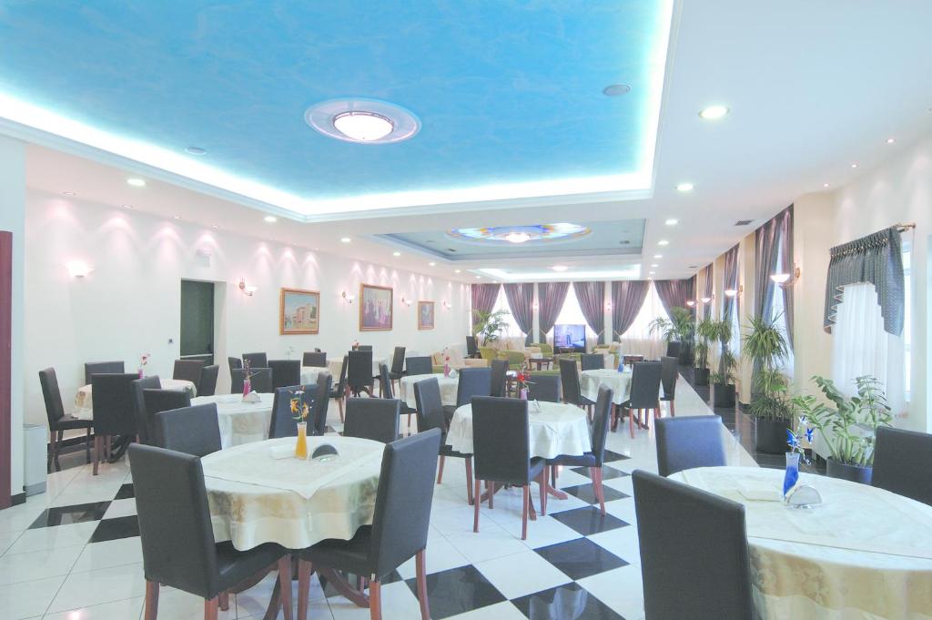 雅典柏拉图酒店的餐厅设有桌椅和蓝色天花板。