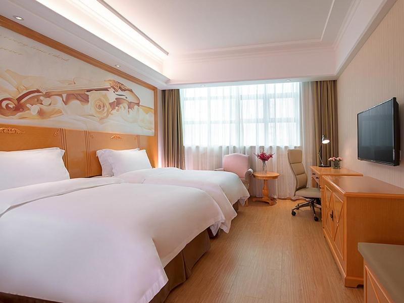 深圳维也纳3好酒店深圳爱榕路店的酒店客房设有两张床和电视。