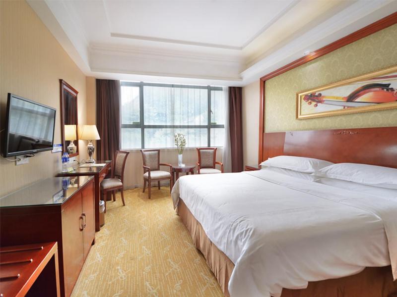 广州维也纳酒店广州同和店的酒店客房配有一张床、一张书桌和一台电视。