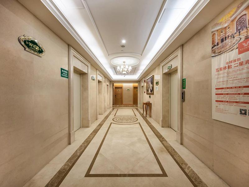 福州维也纳国际酒店福州仓山万达店的建筑中带有标志的长走廊的走廊