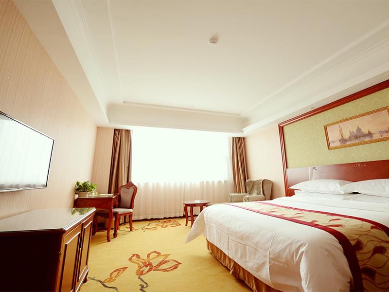 上海维也纳酒店上海嘉定新城店的配有一张床和一张书桌的酒店客房