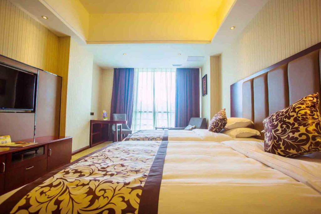 福州维也纳国际酒店福州仓山龙福店的酒店客房设有两张床和一台平面电视。