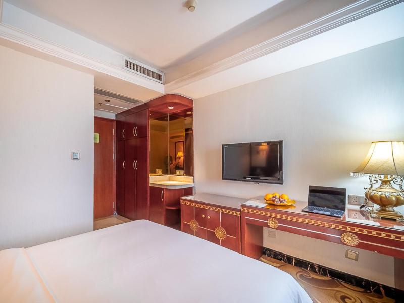 佛山维也纳酒店佛山禅城祖庙店的一间卧室配有一张床和一张书桌及电视