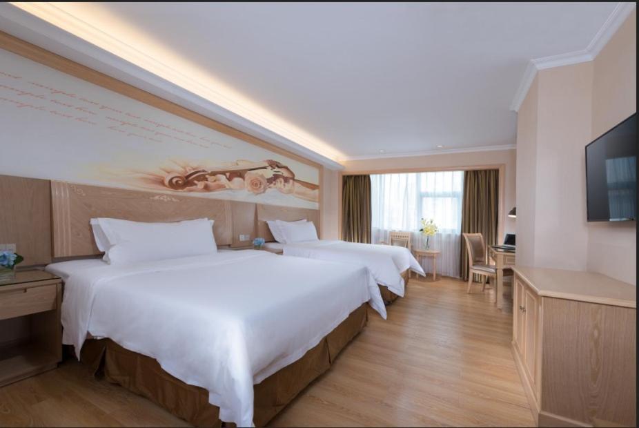深圳维也纳酒店深圳海湾店的酒店客房设有两张床和电视。